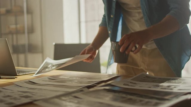 Young Creative Designer Works on a Storyboard, Looks at His Sketches and Concepts, Choosing the Best Drawings for His Project