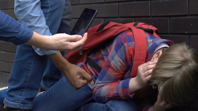 Violent group of teenagers pushing nerd student and shooting on cam on backyard