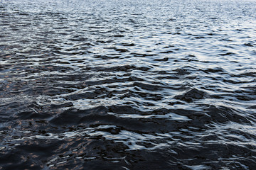 Obraz premium Dark water surface background with small waves and reflections. Dangerous deep river.