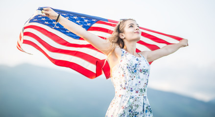 Young happy american woman holding USA flag
