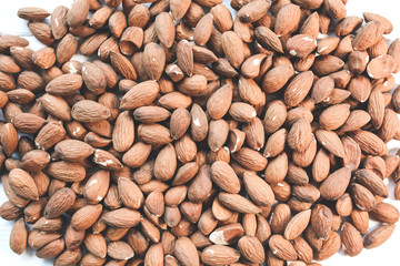 Almond nuts lying on white background. Healthy food. Vegan concept. Lifestyle. Vertical.
