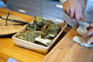 Chef shelling oysters in a country kitchen 