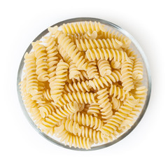Uncooked fusilli pasta in glass bowl isolated on white background with clipping path