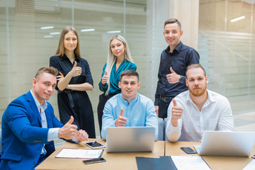 team of young professionals men and women at work in the office with a gesture of hands