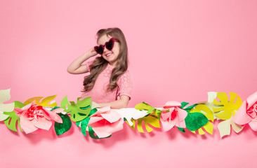 Obraz na płótnie Canvas Portrait of a little girl with sunglasses on a pink background