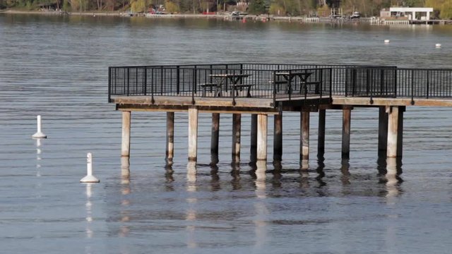 Close Up Of Wooden Pier Over Peaceful Lake Near Beach On Okanagan Lake On Calm Summer Day