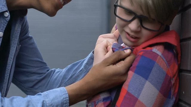 Afro-american guy attacking plump caucasian boy in glasses, outsider bullying