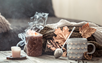 Cozy autumn morning breakfast in bed still life scene. Steaming cup of hot coffee, tea standing near window. Fall.