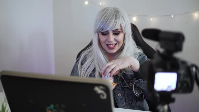 Girl vlogger is testing and reviewing cosmetics in front of professional camera