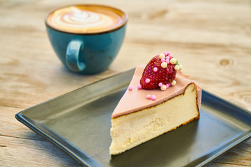 Delicious latte coffee and cheesecake on the wooden table