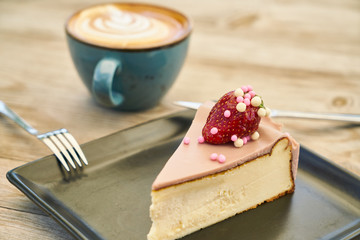 Delicious latte coffee and cheesecake on the wooden table