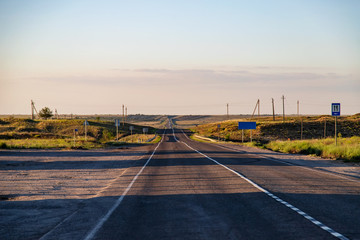 Old asphalt road going beyond the horizon in the steppe area