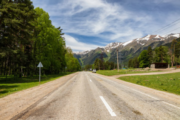 old asphalt road goes away against background of  great mountains