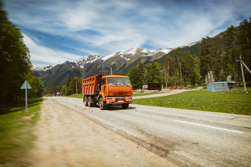 Orange road service truck rides on a mountain road
