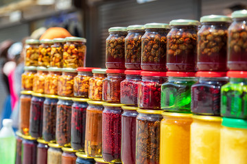 Fototapeta na wymiar Small colorful glass jars with jam from local berries, herbs, roots and nuts