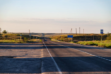 Old asphalt road going beyond the horizon in the steppe area