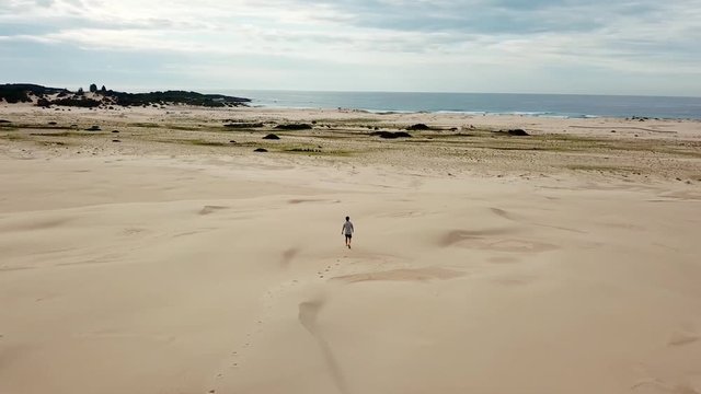 Cinematic Drone Aerial of Big Sandy Landscape With Lonely Man Walking to Beach in Stockton National Park Australia 4k