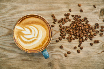 Latte coffee and coffee beans on the wooden table