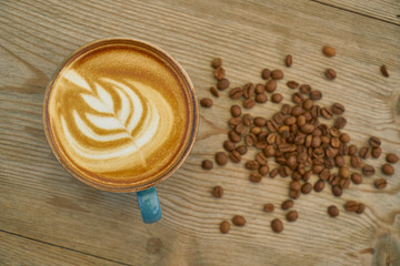 Latte coffee and coffee beans on the wooden table