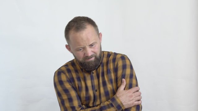 concept of emotions close-up of a bearded man in a plaid shirt on a white background who is holding his stomach with both hands shows that he is tormented by pain