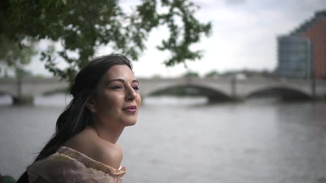 Close Up of an attractive latina tourist looking at river Thames in London, slow motion shot