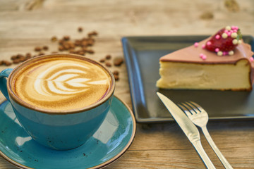Latte coffee and cheesecake on the wooden table