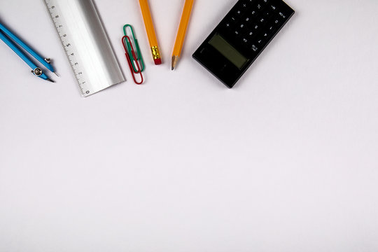 Minimal work space, flat lay photo of workspace desk. Top view office desk with pencil, circus and calculator on white color background. Banner background with copy space