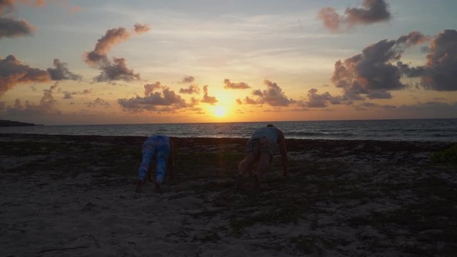Young travel couple enjoying the sunset with a Yoga sesseion.