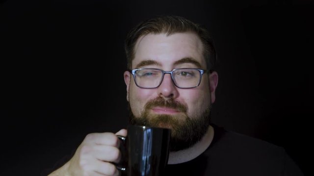Motion studio portrait of a bearded man enjoying a delicious cup of coffee