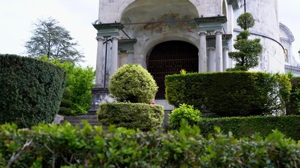 A mother and her little daughter carrying a teddy bear visiting the sacred mountain of Varallo christian devotional complex, a unesco world heritage site near the town of Varallo Sesia in Italy