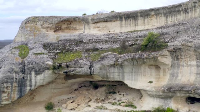 Close up f cave dwellings in rocks. Ancient city fortress on impregnable rock. Medieval cave city. View of valley from plateau. Archaeological site. Historical cave town