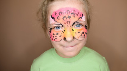 Adorable little girl with colorful painted face.