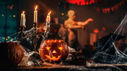 Foto op Canvas Halloween Still Life Colorful Theme: Scary Decorated Dark Room with Table Covered in Spider Webs, Burning Pumpkin, Candlestick, Witch's Hat and Skeleton. In Background Silhouette of Monster Walking By © Gorodenkoff