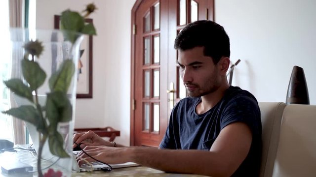 young Handsome Asian man works hard on his laptop, focused and working hard with external hard drives