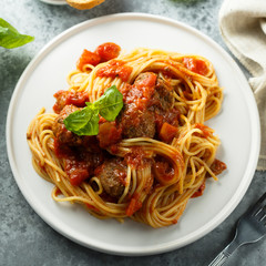 Pasta with meatballs, tomato sauce and basil