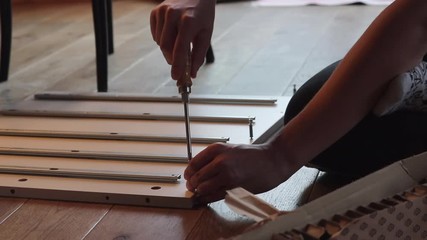 Close Up Of Teenage Boy Assembling A Flat Pack Shelf On The Floor