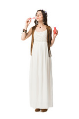 full length view of pregnant woman blowing soap bubbles isolated on white