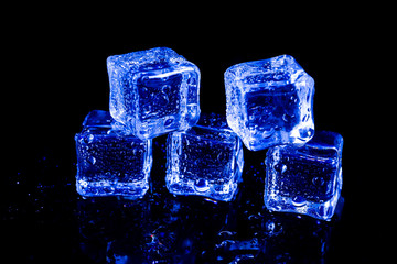 ice cubes in blue light on a black table.