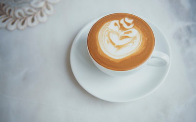 latte or Cappuccino with frothy foam, coffee cup top view on table in cafe.