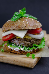 burger with homemade whole grain bun, beef cutlet, tomatoes, onion, salad, mozzarella, yogurt and mustard. healthy food. proper nutrition fast food