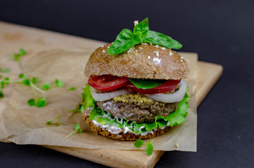 burger with homemade whole grain bun, beef cutlet, tomatoes, onion, salad, mozzarella, yogurt and mustard. healthy food. proper nutrition fast food
