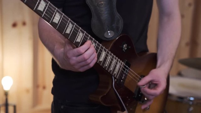 Left Handed Solo Guitarist Playing Electric Guitar During Song Recording Session in Live Room of Professional Studio Close Up