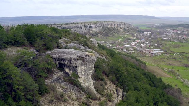 Flying over a beautiful high rocky plateau. Natural education. An ancient impregnable city carved high into rocks. Medieval historical settlement carved into rocks. Aerial shots