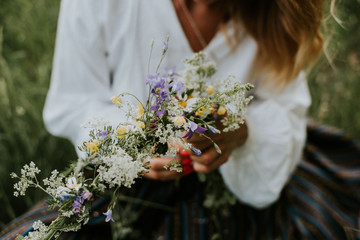 Folk girl in the midsummer making flower - obrazy, fototapety, plakaty