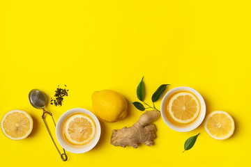 Ginger lemon tea or detox drink in a white cup on a bright yellow background. Healthy eating concept. Copy space.
