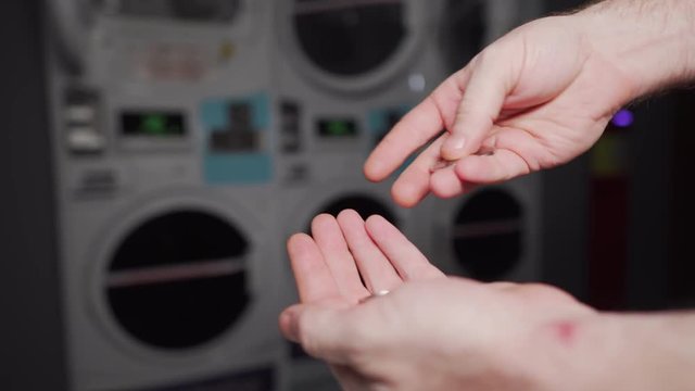 Hand with coins at Laundry Machine washing counting cash