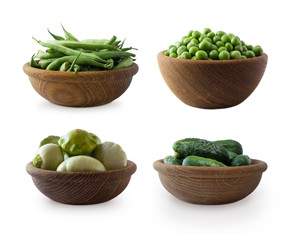 Fresh green vegetables isolated on a white background. Squash, green peas, cucumbers and green bean in wooden bowl. Vegetables with copy space for text. Vegetables isolated on a white.