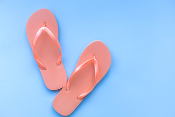 Living coral flip flops on a blue background. Color of the year 2019. Living coral. Place for text.
