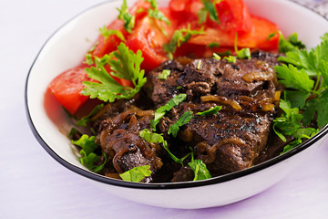 Roasted or grilled beef liver with onion and tomatoes salad. Middle Eastern cuisine.