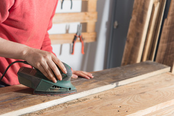 woman sanding a restored wood